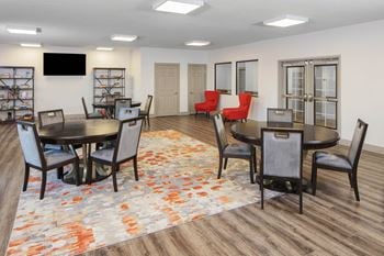 A community room with a table and chairs and a tv